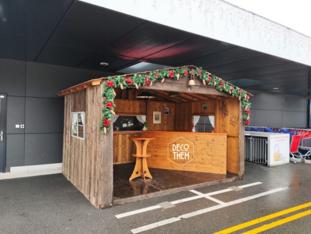 Stand de promotion, chalet en bois, décorations de noël, distribution de vin chaud, bar, mange-debout, guirlandes lumineuses