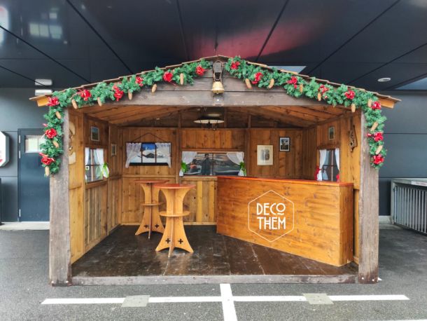 Stand de promotion, chalet en bois, décorations de noël, distribution de vin chaud, bar, mange-debout, guirlandes lumineuses