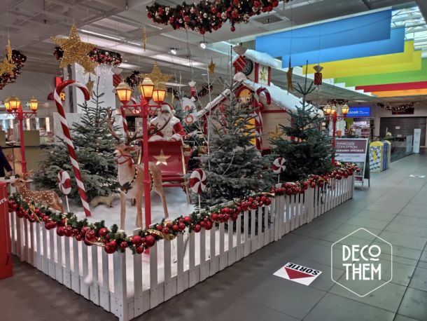 Noël Gruyère Centre l'atelier du Père-Noël et son traîneau, barrières blanches, forêt enneigée, sapins enneigés, renne du Père-Noël, traîneau du Père-Noël, Père-Noël, lampadaires rouge, atelier du Père-Noël, sucettes géantes, cannes à sucre, guirlandes illuminées, étoiles, jouets, casse-noisettes