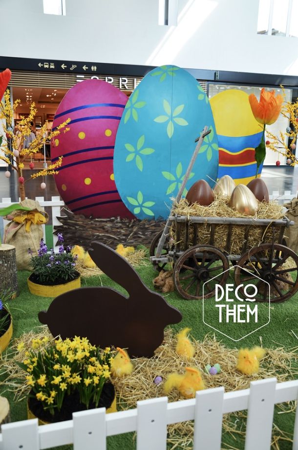 Décoration pâques, barrières blanche, tulipes géantes, gazon, parterre fleuri, charrettes avec des gros œufs, forsythia en fleurs, œufs de pâques géants, poussins , paille