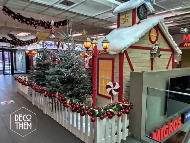 Noël Gruyère Centre l'atelier du Père-Noël et son traîneau, barrières blanches, forêt enneigée, sapins enneigés, renne du Père-Noël, traîneau du Père-Noël, Père-Noël, lampadaires rouge, atelier du Père-Noël, sucettes géantes, cannes à sucre, guirlandes illuminées, étoiles, jouets, casse-noisettes
