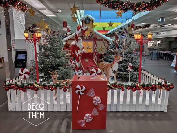 Noël Gruyère Centre l'atelier du Père-Noël et son traîneau, barrières blanches, forêt enneigée, sapins enneigés, renne du Père-Noël, traîneau du Père-Noël, Père-Noël, lampadaires rouge, atelier du Père-Noël, sucettes géantes, cannes à sucre, guirlandes illuminées, étoiles, jouets, casse-noisettes