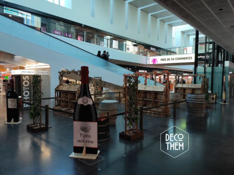 Stands de présentations, présentoirs et éléments de décor créés spécialement à l'occasion de la foire aux vin à Marin Centre Foire aux vins Marin centre, bouteilles peintes, tonneaux, tables hautes,vin, vignes, présentoirs, portique